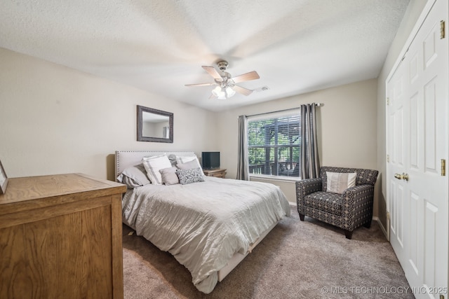 bedroom featuring a ceiling fan, visible vents, baseboards, a closet, and carpet