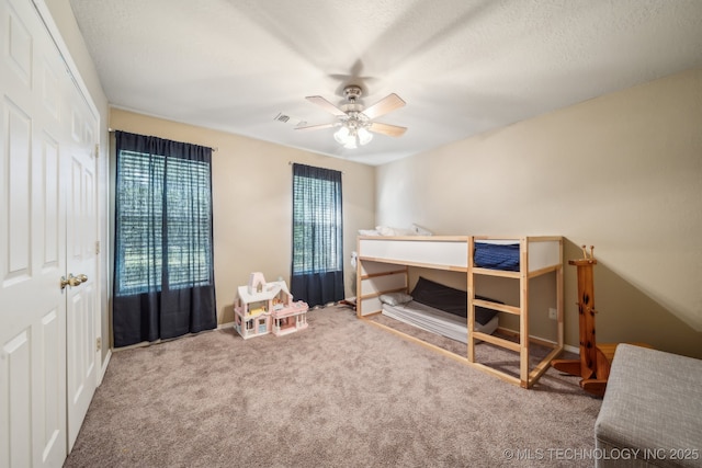 carpeted bedroom with visible vents, baseboards, and ceiling fan