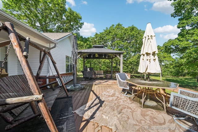 view of patio featuring a gazebo, a wooden deck, and outdoor dining area