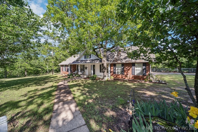view of front of house with brick siding, covered porch, and a front yard