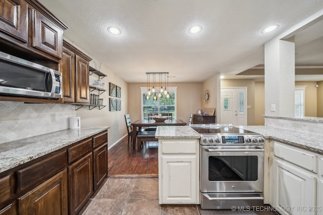 kitchen featuring baseboards, dark brown cabinetry, tasteful backsplash, and stainless steel appliances