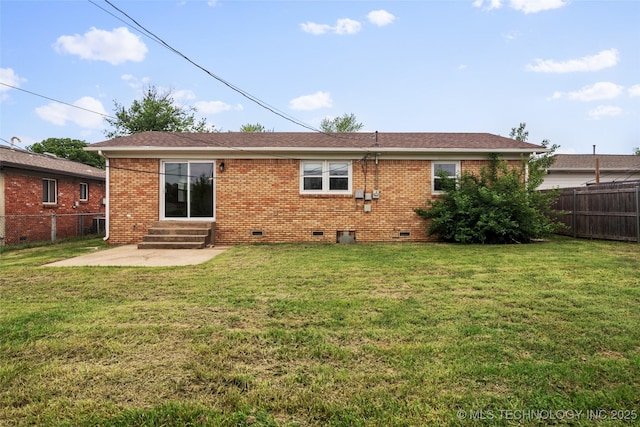 rear view of property with a yard, crawl space, and fence