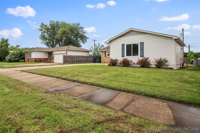 ranch-style home with an attached garage, fence, a front yard, and concrete driveway