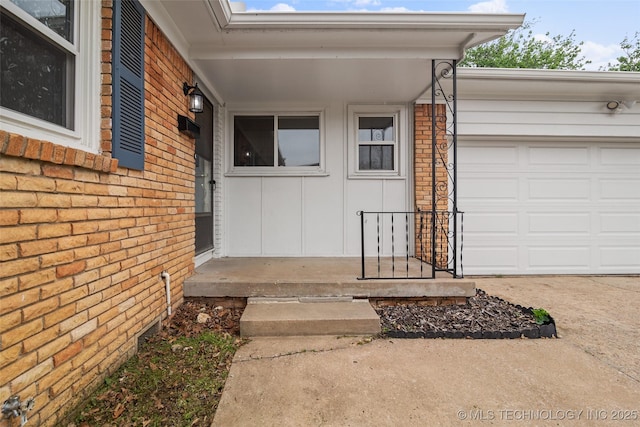 property entrance featuring an attached garage, board and batten siding, and brick siding
