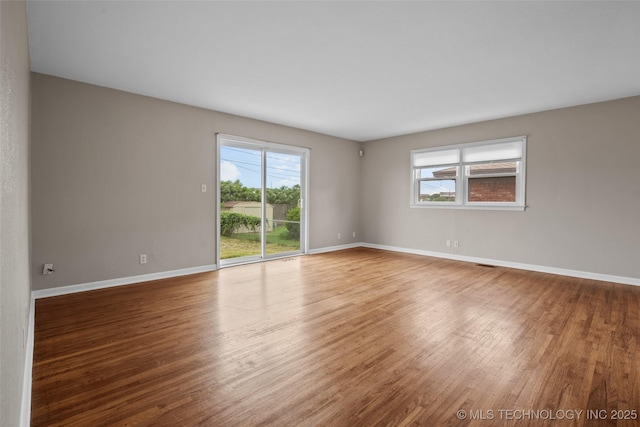 unfurnished room with baseboards and wood finished floors