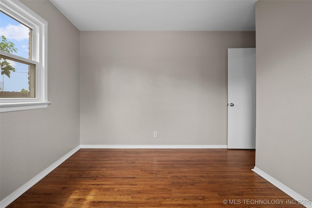 empty room featuring baseboards and wood finished floors