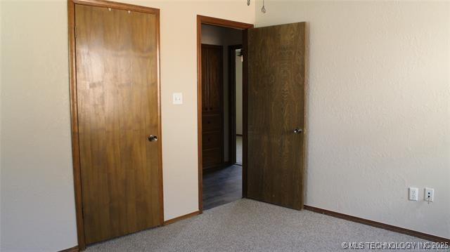 unfurnished bedroom featuring carpet flooring and baseboards