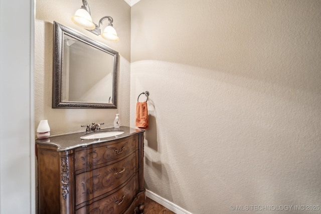 bathroom featuring vanity, baseboards, and wood finished floors