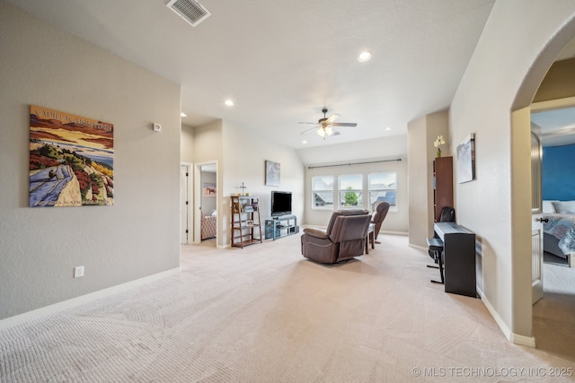 living area with ceiling fan, light colored carpet, visible vents, arched walkways, and recessed lighting