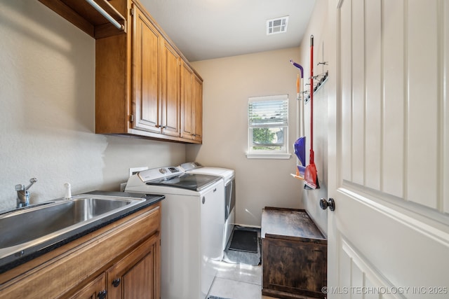 laundry room with a sink, separate washer and dryer, cabinet space, and visible vents
