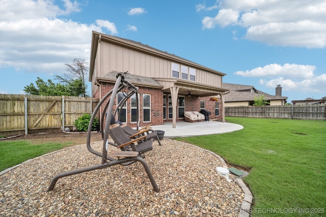 rear view of house featuring a fenced backyard, brick siding, a ceiling fan, a patio area, and a yard