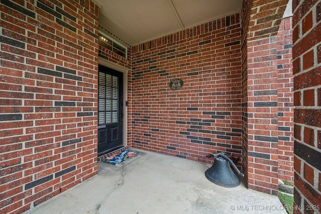 property entrance featuring brick siding