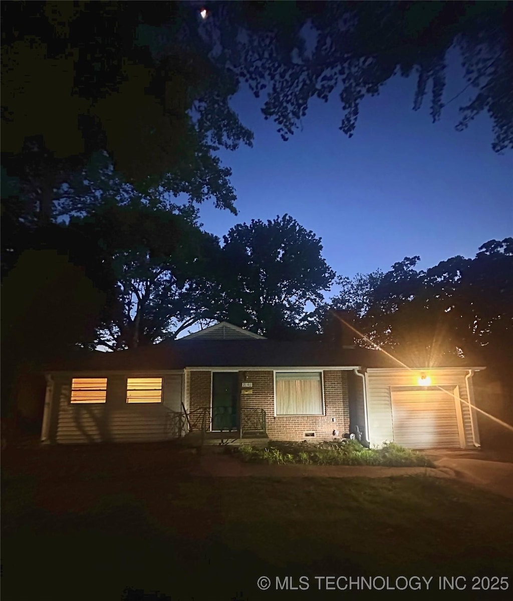 view of front of home with an attached garage and brick siding