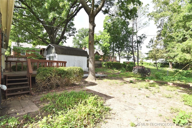 2140 S Columbia Ave, Tulsa, OK 74114 - view of yard featuring a wooden deck, an outdoor structure, and a storage unit