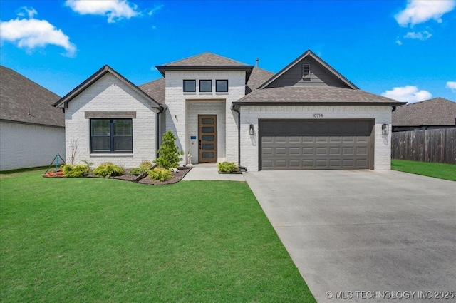 view of front facade with an attached garage, a front yard, driveway, and brick siding