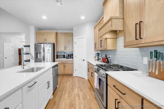 kitchen featuring visible vents, a sink, light countertops, and stainless steel appliances