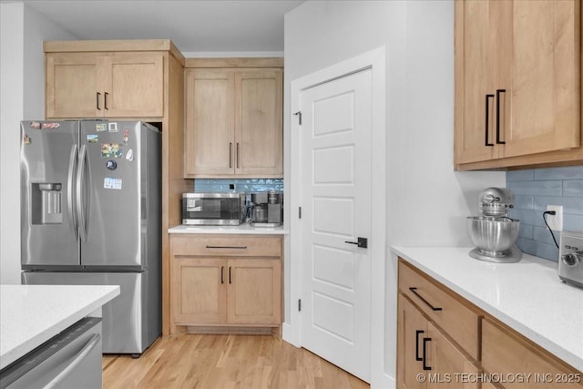 kitchen featuring light countertops, decorative backsplash, and stainless steel appliances