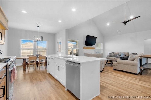 kitchen featuring stainless steel appliances, a healthy amount of sunlight, a sink, and light wood finished floors