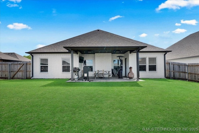rear view of property featuring a fenced backyard, a patio area, and brick siding