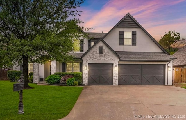 view of front of house featuring stone siding, a garage, stucco siding, concrete driveway, and a yard