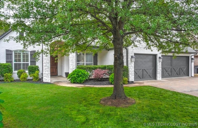 obstructed view of property with a garage, stone siding, concrete driveway, and a front yard