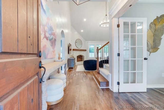 bathroom with recessed lighting, an inviting chandelier, a stone fireplace, and wood finished floors