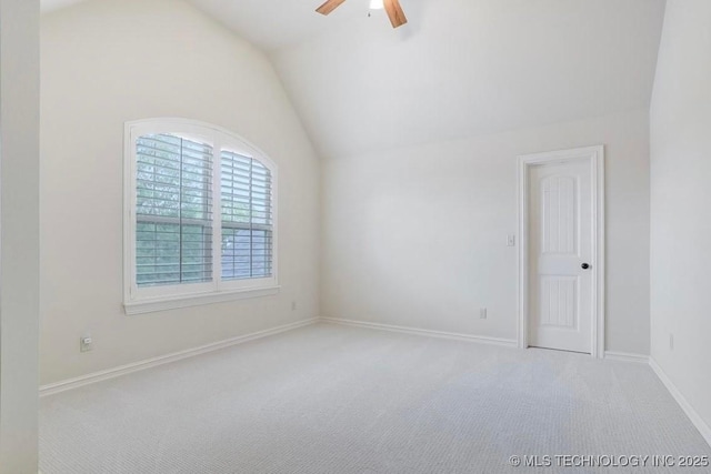 carpeted spare room featuring baseboards, ceiling fan, and lofted ceiling