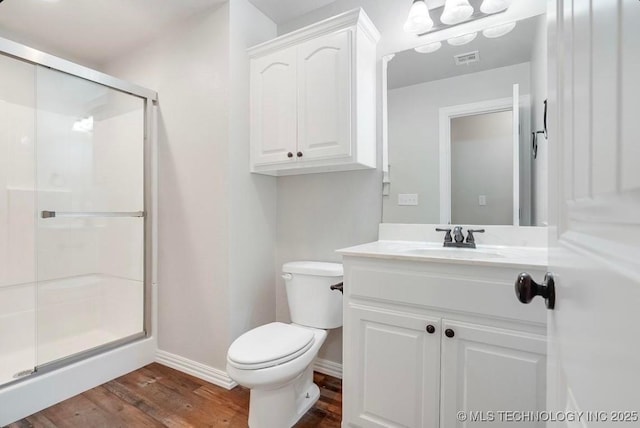 full bath featuring visible vents, vanity, wood finished floors, baseboards, and a stall shower