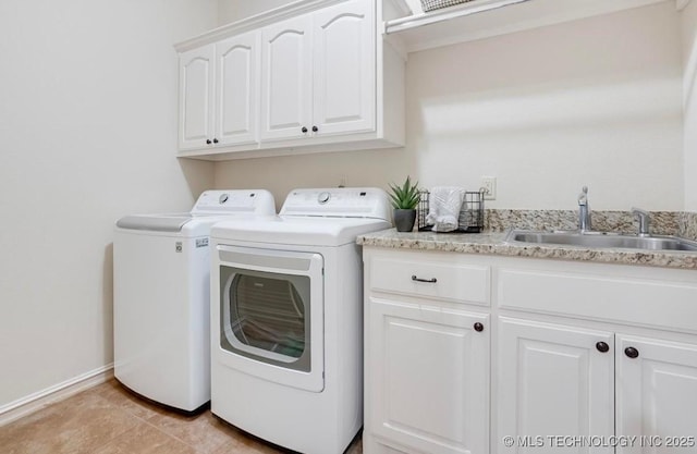 laundry room with a sink, light tile patterned floors, cabinet space, and washer and dryer