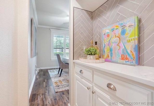 hall featuring crown molding, baseboards, and dark wood finished floors