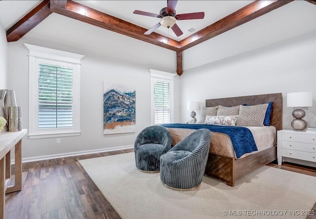 bedroom with a ceiling fan, visible vents, beam ceiling, wood finished floors, and baseboards