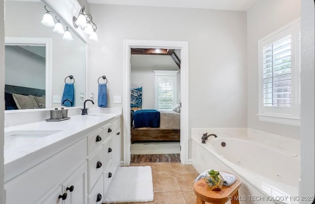 ensuite bathroom with connected bathroom, a sink, double vanity, tile patterned floors, and a garden tub