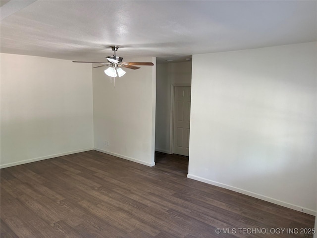 spare room featuring dark wood-type flooring, baseboards, and ceiling fan