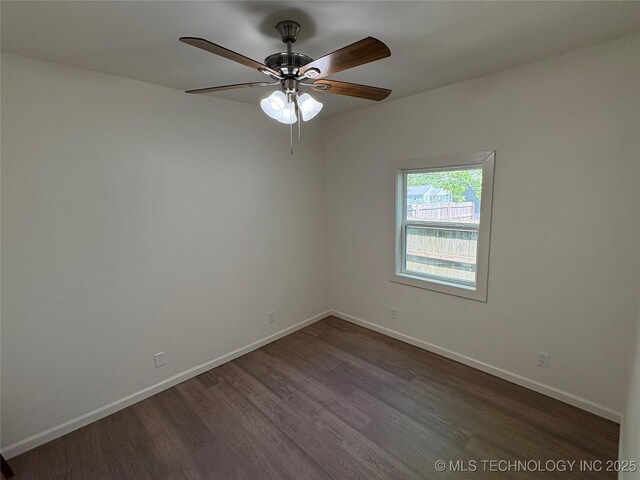 empty room featuring baseboards, dark wood-style flooring, and ceiling fan