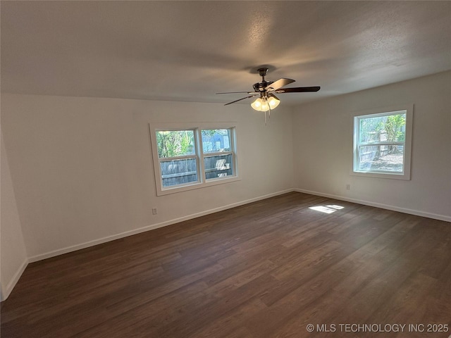 unfurnished room featuring baseboards, a ceiling fan, and dark wood-style flooring