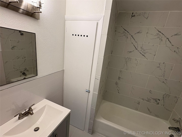full bath with shower / washtub combination, tile walls, and vanity