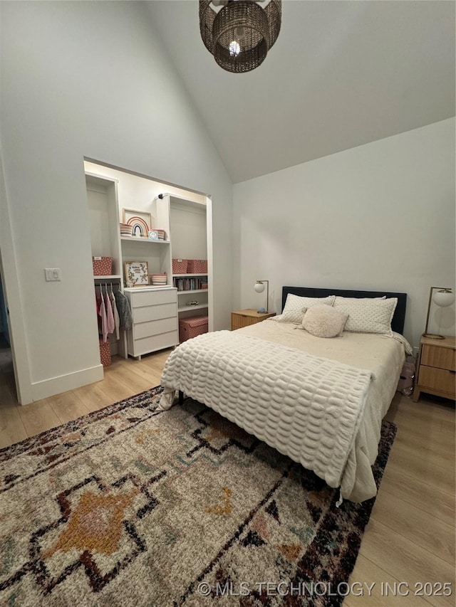 1583 E Clara Ct, Fort Gibson, OK 74434 - bedroom with an inviting chandelier, baseboards, wood finished floors, and high vaulted ceiling