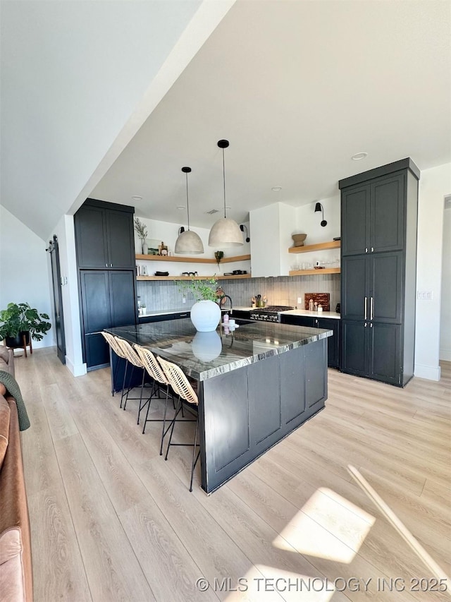 1583 E Clara Ct, Fort Gibson, OK 74434 - kitchen featuring open shelves, a sink, light wood finished floors, dark stone counters, and backsplash