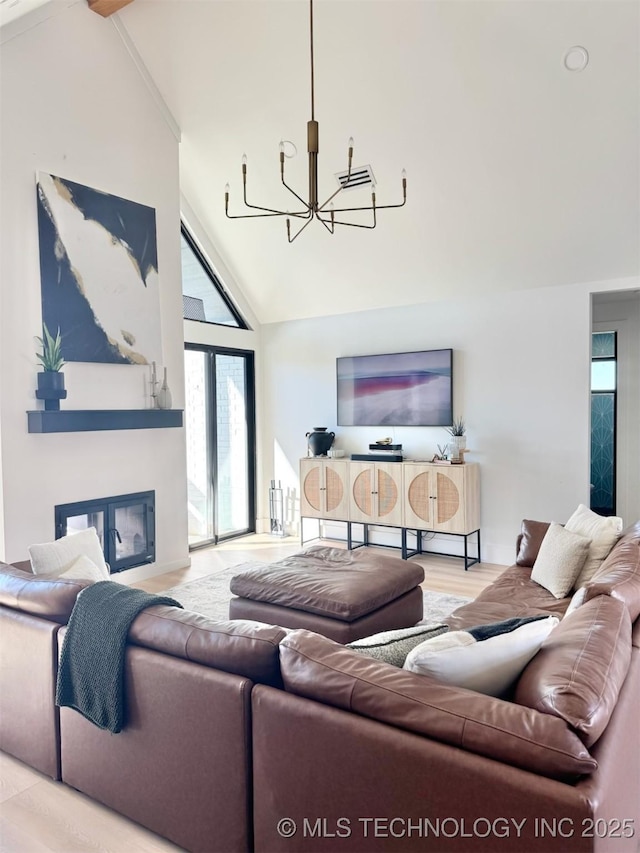 1583 E Clara Ct, Fort Gibson, OK 74434 - living room featuring high vaulted ceiling, a chandelier, a glass covered fireplace, and wood finished floors