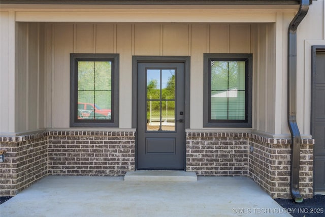 doorway to property featuring board and batten siding and a porch