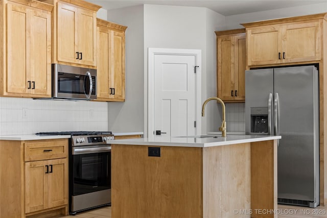kitchen with light countertops, appliances with stainless steel finishes, light brown cabinetry, and tasteful backsplash