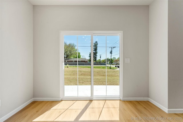 doorway to outside with baseboards and wood finished floors