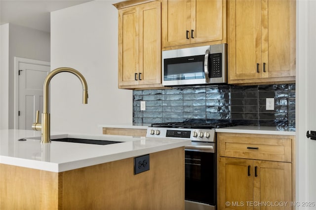 kitchen with light countertops, tasteful backsplash, stainless steel appliances, and a sink