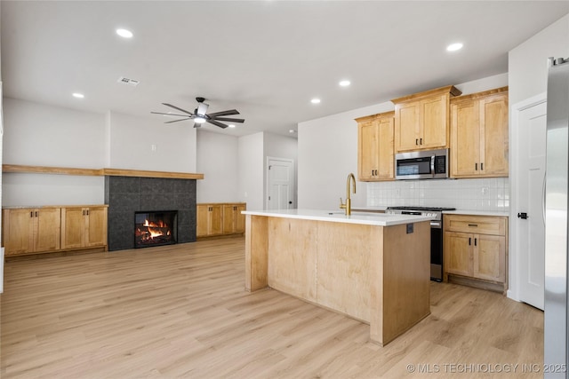 kitchen featuring visible vents, light wood-style floors, light countertops, appliances with stainless steel finishes, and backsplash
