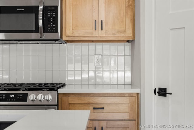 kitchen featuring decorative backsplash, appliances with stainless steel finishes, and light countertops