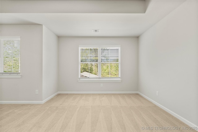 empty room with carpet floors, baseboards, and visible vents