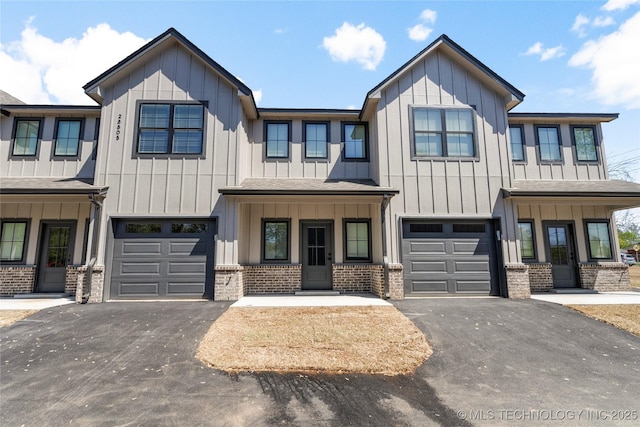 view of front of property featuring board and batten siding, an attached garage, and driveway