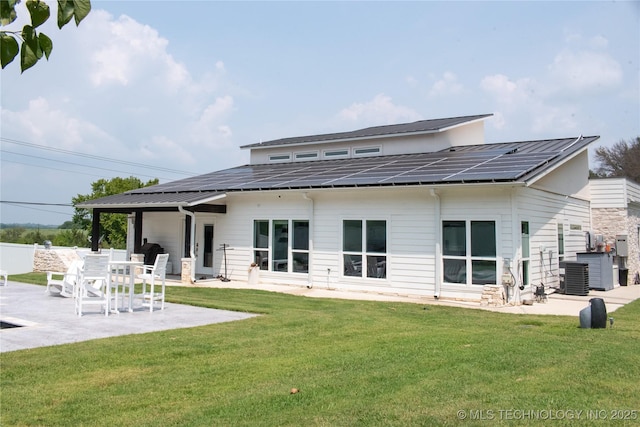 8973 Birch St, Kingston, OK 73439 - back of property featuring roof mounted solar panels, a lawn, a patio area, and metal roof