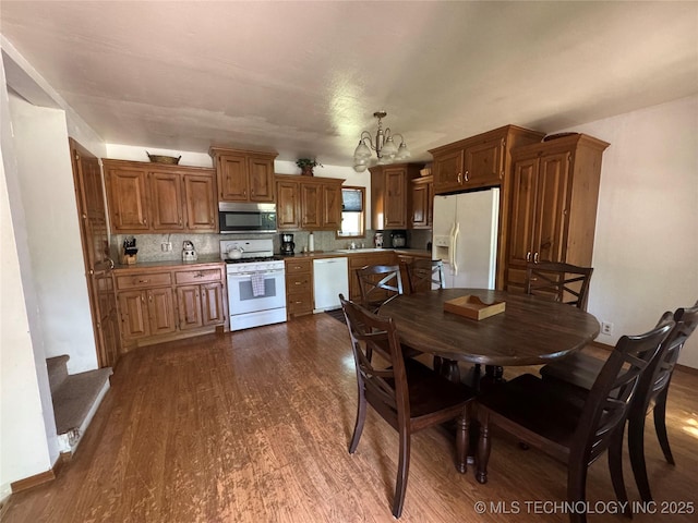 dining area with dark wood-style flooring and a notable chandelier