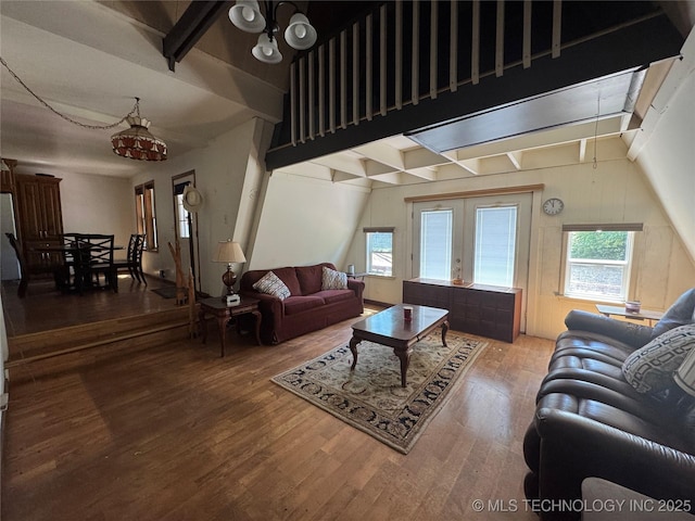 living room featuring wood finished floors, a chandelier, and beam ceiling